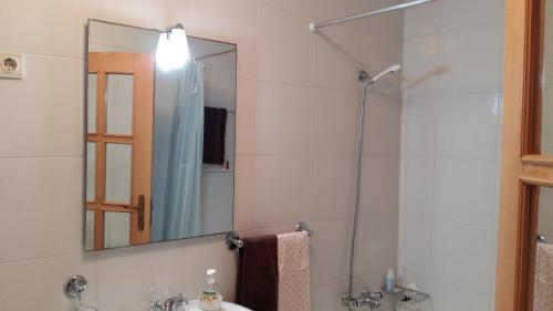 een badkamer met een wastafel en een douche met een spiegel bij Casa Vista Mar Torreira in Torreira