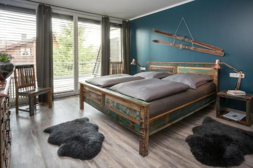 オーベルストドルフにあるStudio im Loftの青い壁のベッドルーム1室(大型ベッド1台付)