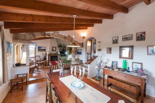 a kitchen and living room with wooden ceilings and a table at Villa Son Fullos in Santa Margalida
