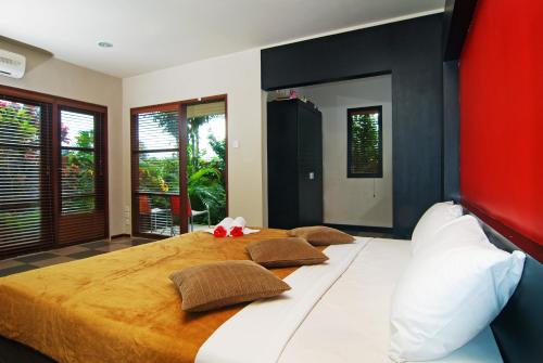 a bedroom with a large white bed with pillows at Taman Ayu Town House in Denpasar