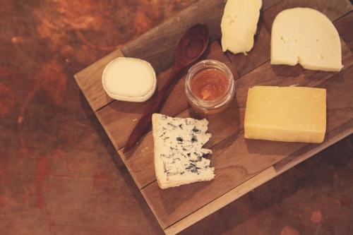 une planche à découper en bois avec du fromage et d'autres aliments dans l'établissement Maison De L'Orb, à Béziers