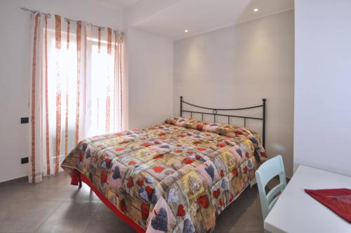 a bedroom with a bed and a table and a window at La rosa dei venti - Cetara in Cetara