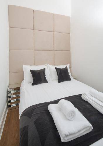 a large white bed with two white towels on it at Edinburgh Castle Apartments in Edinburgh