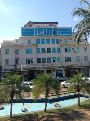 a large building with palm trees in front of it at Palace Hotel in Araguari