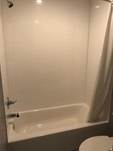 y baño con bañera blanca y aseo. en Super 8 by Wyndham Sonora, en Sonora