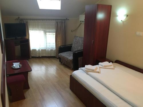 Cette petite chambre comprend un lit et un canapé. dans l'établissement Pensiunea Belvedere, à Craiova