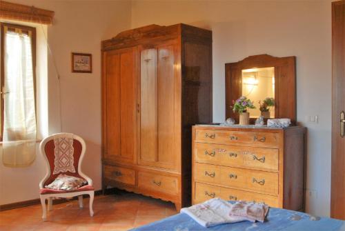 a bedroom with a dresser and a cabinet and a chair at La Capannella in Gallicano