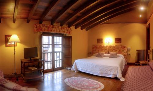 a bedroom with a white bed and a television at Posada Andariveles in Quijas