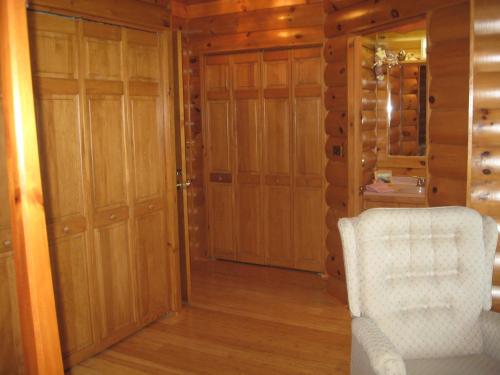 a living room with a white chair and wooden walls at Serenity On The Lake in Auburn