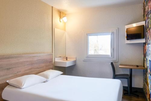 a hotel room with a bed and a sink at hotelF1 Chartres in Le Coudray