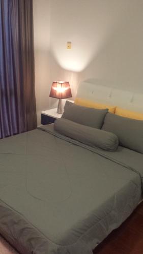 a bedroom with a large bed with a lamp at VH Homes, Imago Shopping Mall in Kota Kinabalu