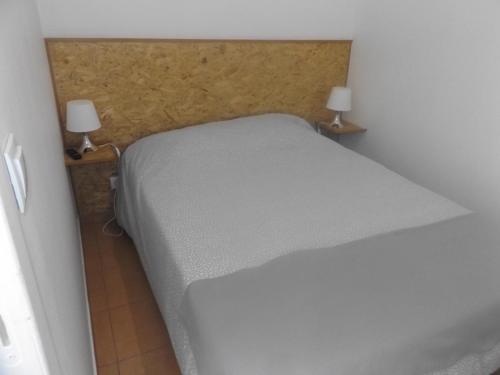 a small bedroom with a bed with two lamps on it at Casa do Largo in Porto