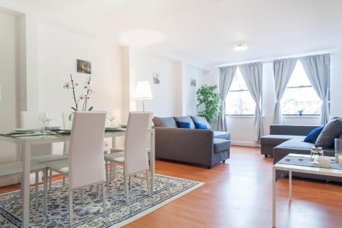 a living room with a table and a couch at The Queensborough Apartments by Hyde Park in London