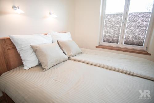 a bed with white sheets and pillows in a bedroom at Maria 4 Apartment in Tartu