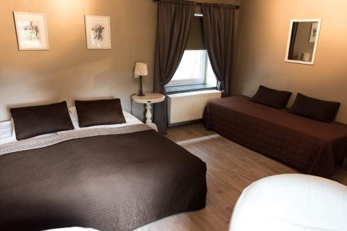 sypialnia z 2 łóżkami, kanapą i oknem w obiekcie Maison Les Anges w mieście Bouillon