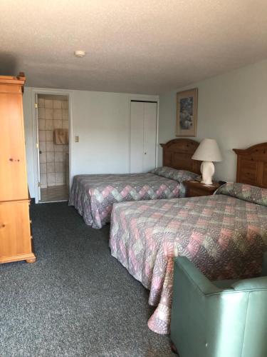 a hotel room with two beds and a lamp at Windswept Motel in Point Pleasant Beach