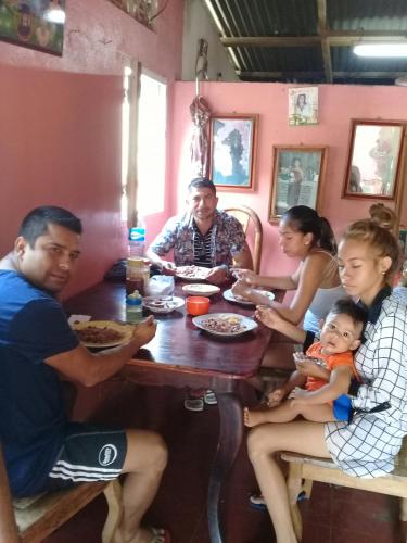 a group of people sitting at a table eating food at Guest House Nena in Moyogalpa