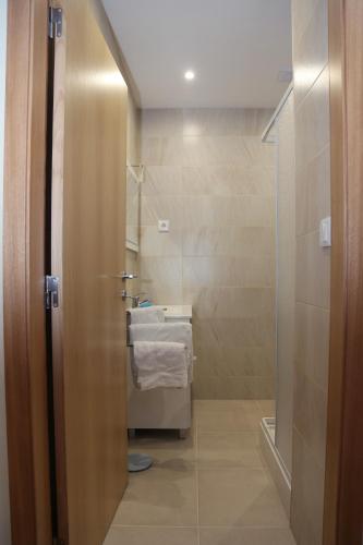 a bathroom with a sink and a toilet and a shower at Colina do Ave Alojamento Local in Ribeirão