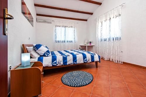 sypialnia z łóżkiem z niebieską i białą pościelą w obiekcie Apartment Bora Rovinj w Rovinj