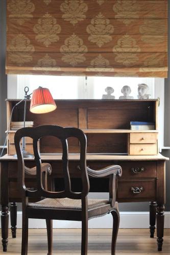 escritorio de madera con silla y lámpara en B&B 't Kasteel & 't Koetshuys, en Veurne