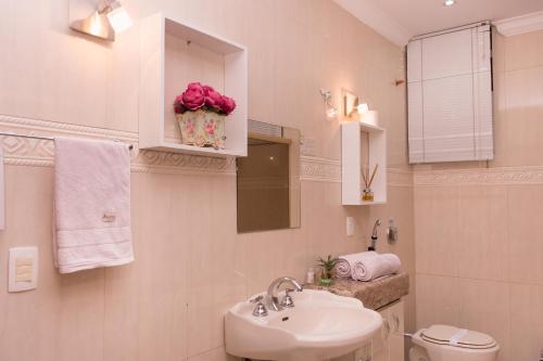 a bathroom with a sink and a toilet and a mirror at Hospedaria Casa Real in Santa Cruz de Minas