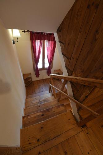 a staircase with wooden floors and a window with red curtains at Ca dei Ciossi in Concordia Sagittaria
