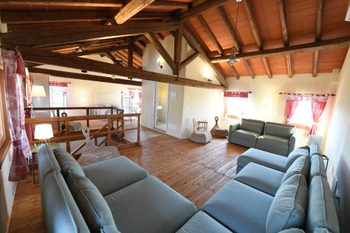 a living room with blue couches and wooden ceilings at Ca dei Ciossi in Concordia Sagittaria