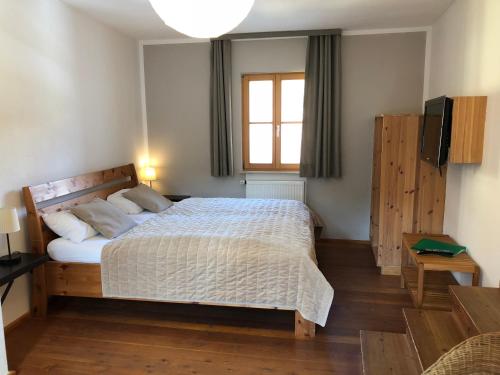una camera con un grande letto e una finestra di Fuchsmühle a Rothenburg ob der Tauber