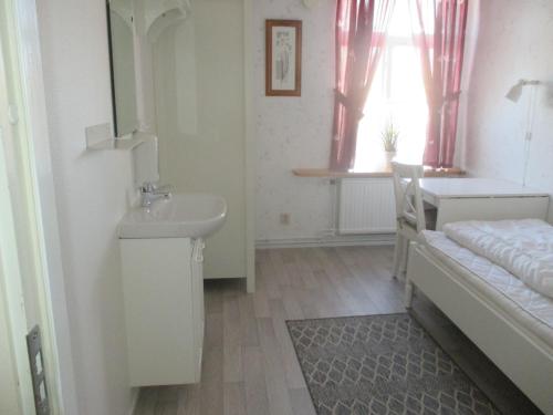 a white bathroom with a sink and a sink at Munkebergs Stugor & Vandrarhem in Filipstad