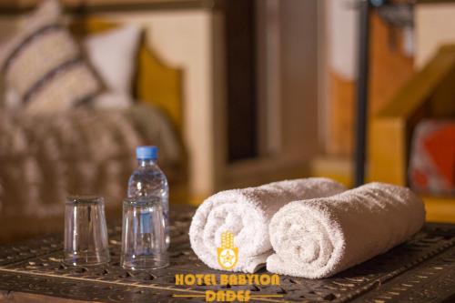 Hotel Babylon Dades في Imdiazene: طاولة مليئة بالمناشف وزجاجة من الماء