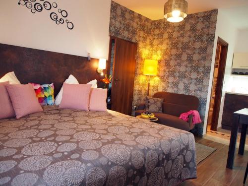 a bedroom with a large bed and a couch at László Nyaralóház in Balatonfenyves
