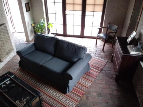 - un salon avec un canapé noir et une chaise dans l'établissement Apartamenty Za Murem, à Poznań