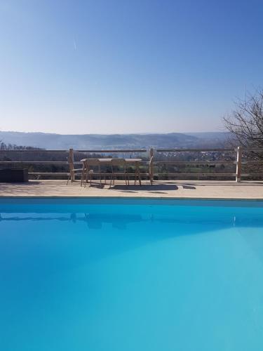 a view of a table and bench from a pool at Le Clos Des Etoiles in Le Bugue