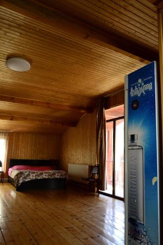 a bedroom with a bed in a room with wooden ceilings at Daeli Hotel in Mestia