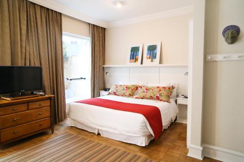 a bedroom with a bed and a flat screen tv at Vitória Hotel Concept Campinas in Campinas
