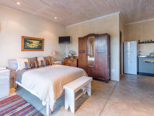 ein Schlafzimmer mit einem großen Bett und einem Kühlschrank in der Unterkunft River Cottage in Kenton on Sea