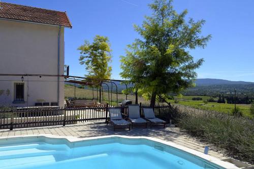 a pool with two chairs next to a house at Masmazan in Mazan