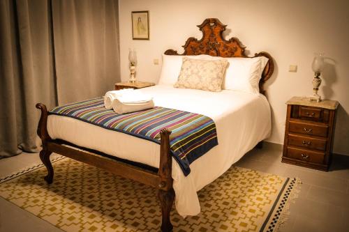 a bedroom with a large bed with a wooden headboard at Domvs Gaia GHouse B&B in Vila Nova de Gaia