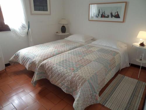 コスタ・ノヴァにあるCasa do Bico da Biaritzのベッドルーム(キルト付きのベッド付)