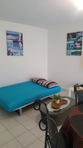 a blue bench in a room with a table at Mers du Sud in Les Trois-Îlets