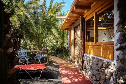 une terrasse couverte d'une maison avec une table et des chaises dans l'établissement Villa Palmeras Canarias, à Uga