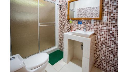 a bathroom with a toilet and a sink and a shower at Cabañas Yakuruna in Leticia