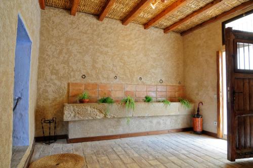 une chambre avec un banc orné de plantes sur le mur dans l'établissement Cal Blai, à Mora la Nueva