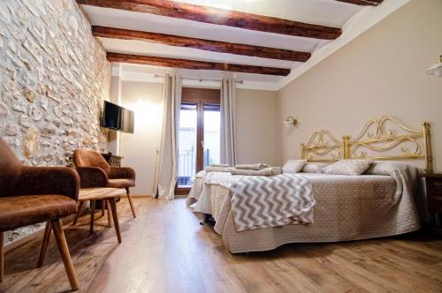 a bedroom with a bed and a stone wall at Cal Blai in Móra la Nova
