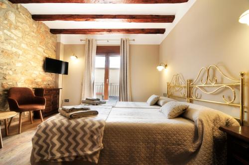a bedroom with a large bed and a chair at Cal Blai in Móra la Nova