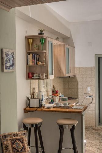 a kitchen with two bar stools and a counter at Kanoni Beach Apartments in Lákka