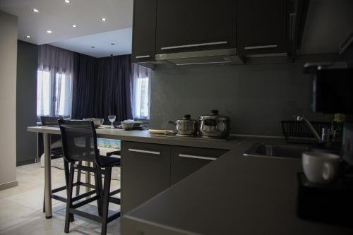 アスプロヴァルタにあるB. U. Luxury Apartmentsのキッチン(黒いキャビネット、カウンタートップ付)