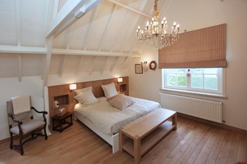 Schlafzimmer mit einem Bett und einem Kronleuchter in der Unterkunft B&B Villa Sans Soucis in Nieuwpoort