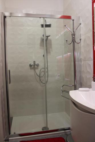 a shower with a glass door next to a sink at Bed Nonnonino in Porto Cesareo