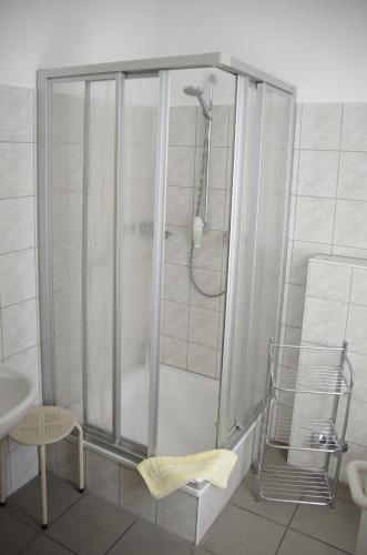 a bathroom with a shower with a chair and a sink at Hotel Eichenhof in Klein Reken